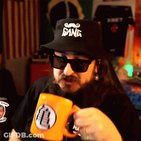 A Man With A Beard Wears A Hat That Says Gang GIF