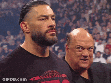 A Man With A Beard Wears A Shirt That Says ' Roman Reigns ' On It GIF