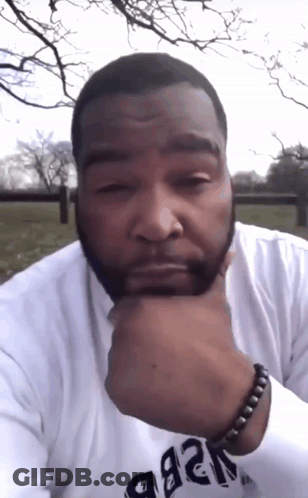 A Man With A Beard Wears A White Shirt That Says ' A & B ' On The Sleeve GIF