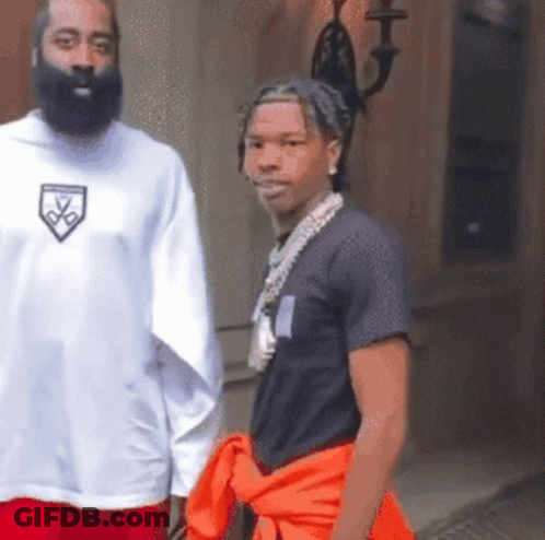 A Man With A Beard Wears A White Shirt With A Shield On The Front GIF