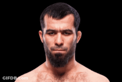 A Man With A Beard Without A Shirt Is Looking At The Camera GIF