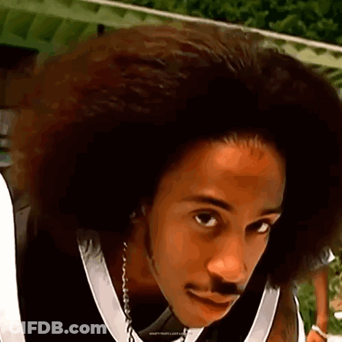 A Man With A Big Afro And A Mustache Is Wearing A Black And White Jersey . GIF