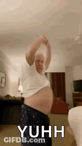 A Man With A Big Belly Is Dancing In A Room . GIF