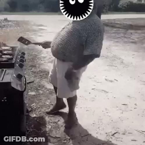 A Man With A Big Belly Is Standing In Front Of A Grill . GIF