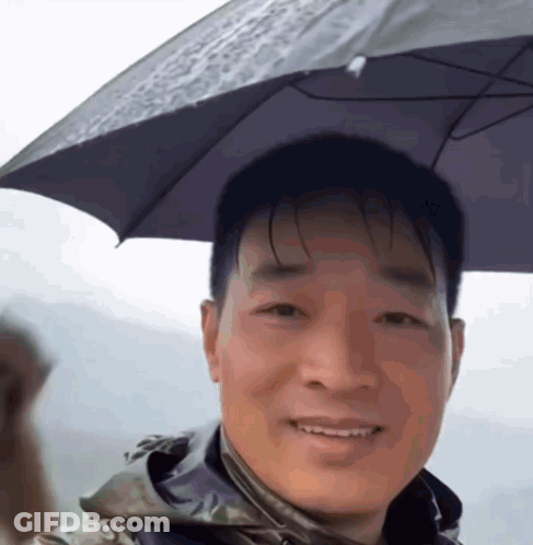 A Man With A Black Umbrella On His Head Smiles GIF