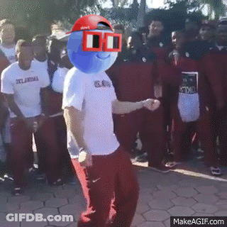 A Man With A Blue Ball On His Head Is Dancing In Front Of A Crowd Of People Wearing Oklahoma Shirts GIF