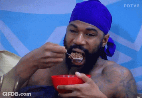 A Man With A Blue Headband Is Eating Cereal From A Bowl GIF