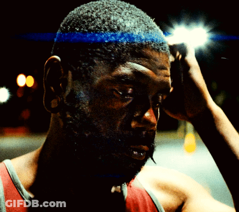 A Man With A Blue Headband On His Head Looks At The Camera GIF