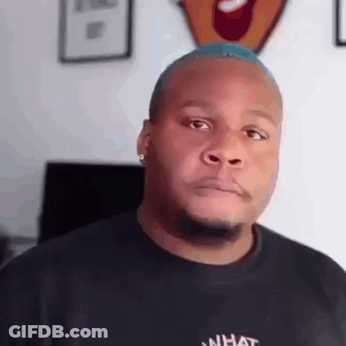 A Man With A Blue Mohawk Is Wearing A Black T-Shirt With The Word What On It . GIF