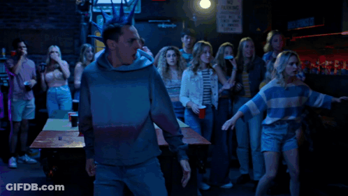 A Man With A Blue Mohawk Stands In Front Of A Sign That Says Connor St. GIF
