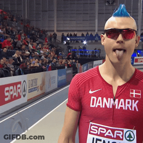 A Man With A Blue Mohawk Wearing Sunglasses And A Red Shirt That Says Danmark GIF