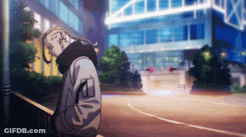 A Man With A Braided Ponytail Is Standing In Front Of A Building GIF