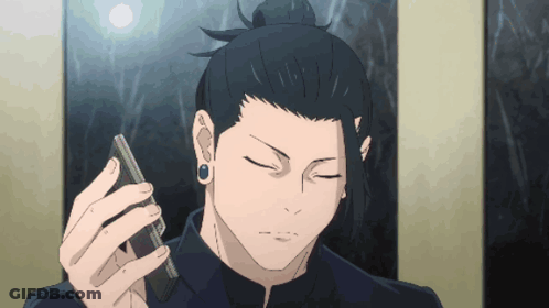 A Man With A Bun Holds A Cell Phone In His Hand GIF