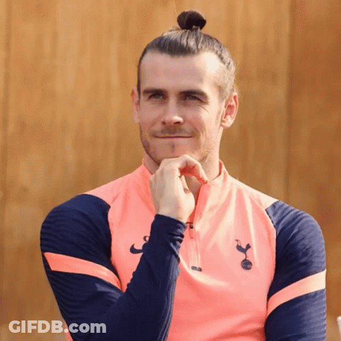 A Man With A Bun On His Head Is Wearing A Pink Shirt With The Letters Tottenham On It GIF