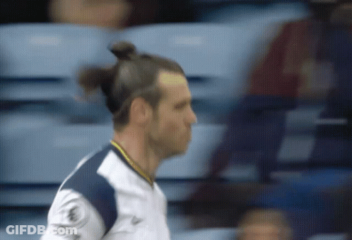 A Man With A Bun On His Head Is Wearing A Shirt That Says ' Allianz ' On It GIF