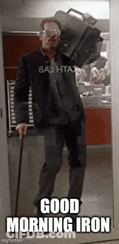 A Man With A Cane Is Carrying A Briefcase On His Shoulder And Says Good Morning Iron . GIF