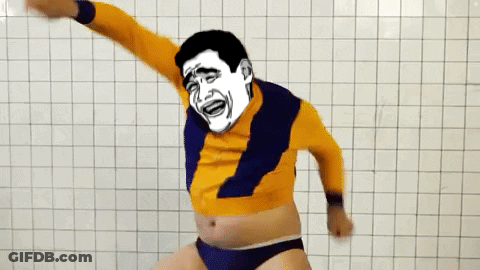 A Man With A Cartoon Face On His Face Is Dancing In Front Of A White Tiled Wall GIF