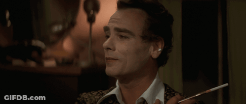 A Man With A Cigarette In His Hand Looks At Something GIF