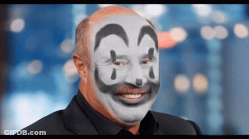 A Man With A Clown Face Painted On His Face Smiling GIF