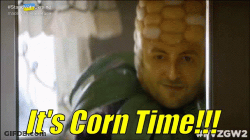 A Man With A Corn On The Cob On His Head Says " It 'S Corn Time " GIF