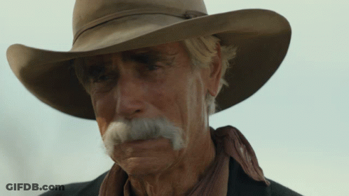 A Man With A Cowboy Hat And A Mustache Looks At The Camera GIF