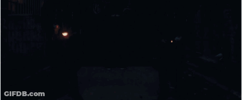 A Man With A Cross On His Back Is Holding A Torch GIF