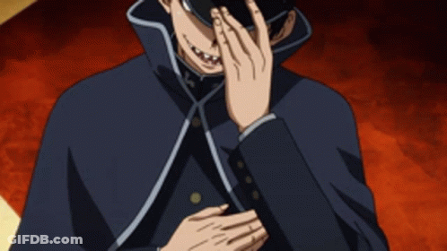 A Man With A Cross On His Hat Is Covering His Face GIF