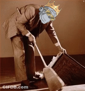 A Man With A Crown On His Head Is Sweeping The Floor With A Broom GIF