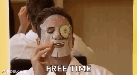 A Man With A Face Mask And Cucumber Slices On His Eyes Is Eating A Sandwich . GIF