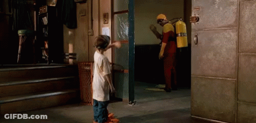A Man With A Fire Extinguisher On His Back Is Standing Next To A Boy In A Room GIF