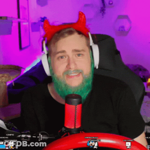 A Man With A Green Beard Is Wearing Headphones And A Red Headband With Horns GIF