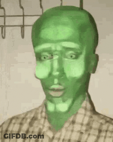 A Man With A Green Face Is Wearing A Plaid Shirt And Has A Green Mask On His Face . GIF