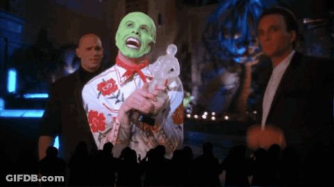 A Man With A Green Mask Is Holding A Rabbit In Front Of A Crowd GIF