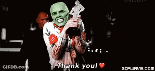A Man With A Green Mask Is Holding A Trophy And Saying Thank You . GIF