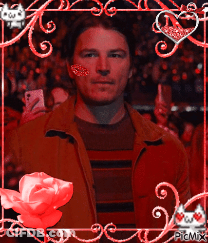 A Man With A Heart On His Cheek Is In A Frame With Hearts And Flowers GIF