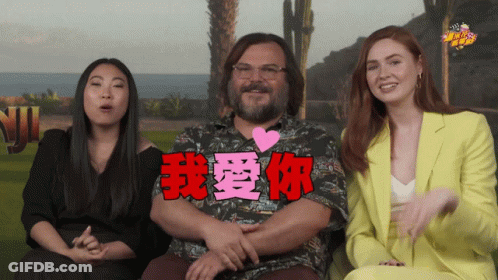 A Man With A Heart On His Chest Is Surrounded By Two Women And A Sign That Says " I Love You " GIF
