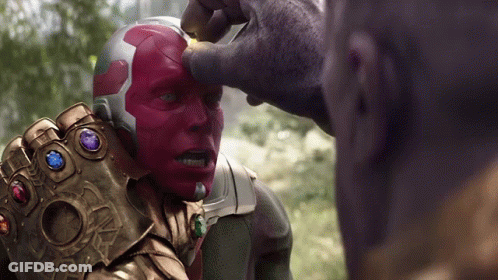 A Man With A Helmet And A Glove With Gems On It Is Being Touched By Another Man GIF