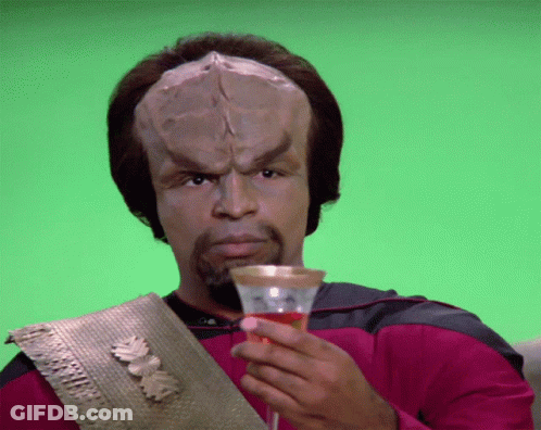 A Man With A Huge Head Is Holding A Glass Of Wine GIF