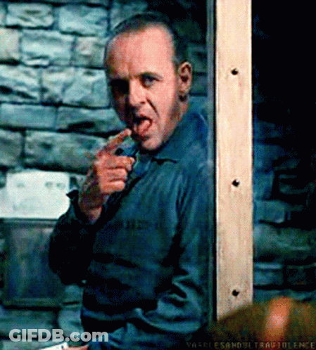 A Man With A Knife In His Mouth Is Standing In Front Of A Brick Wall .. GIF
