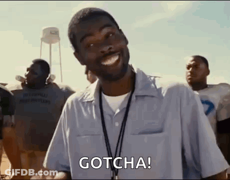 A Man With A Lanyard Around His Neck Is Standing In Front Of A Group Of Football Players And Smiling . GIF