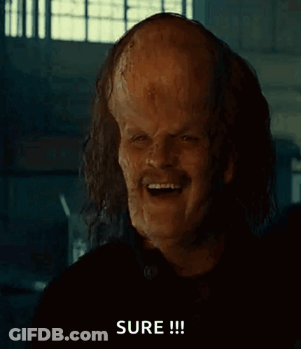 A Man With A Large Bald Head Is Pointing At The Camera And Says Sure GIF