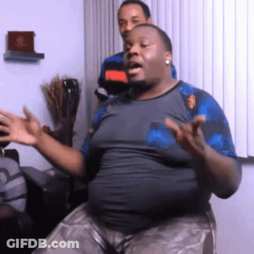 A Man With A Large Belly Is Sitting In Front Of A Window With His Hands Outstretched GIF