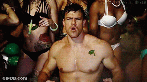 A Man With A Leaf Tattoo On His Chest Is Surrounded By Women In Bikinis .. GIF