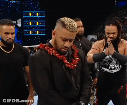 A Man With A Lei Around His Neck Is Standing In A Ring With Other Men GIF