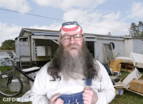 A Man With A Long Beard Wearing Overalls And A Headband With An American Flag On It GIF