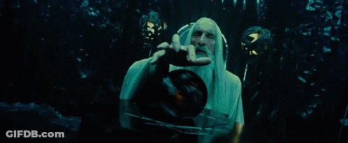 A Man With A Long White Beard Is Holding A Clock In His Hand . GIF