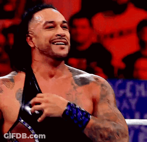 A Man With A Lot Of Tattoos Is Smiling In A Ring GIF