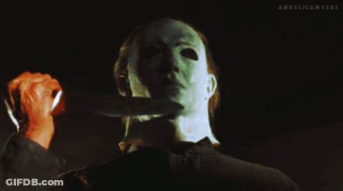 A Man With A Mask Holds A Knife To His Neck And The Words Angelicamyers Are Above Him GIF