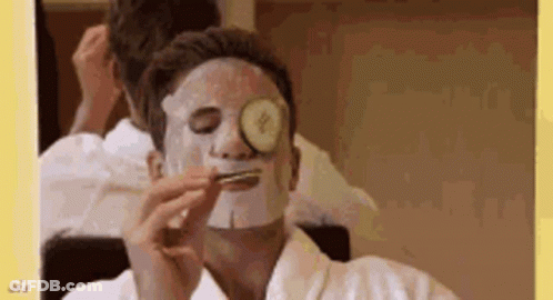 A Man With A Mask On His Face And A Cucumber On His Eye . GIF