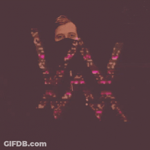 A Man With A Mask On His Face Holds The Letter W GIF